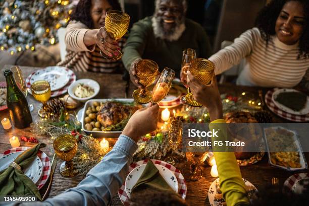 Family Toasting On Christmas Dinner At Home Stock Photo - Download Image Now - Christmas, Dinner, Family