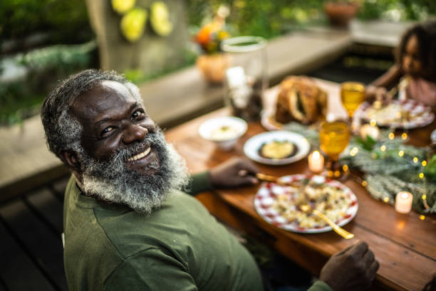 Portrait of a happy senior man during Christmas at home Portrait of a happy senior man during Christmas dinner at home black people eating stock pictures, royalty-free photos & images