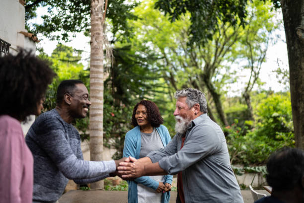 neighbors greeting each other at front house - gemeenschap stockfoto's en -beelden