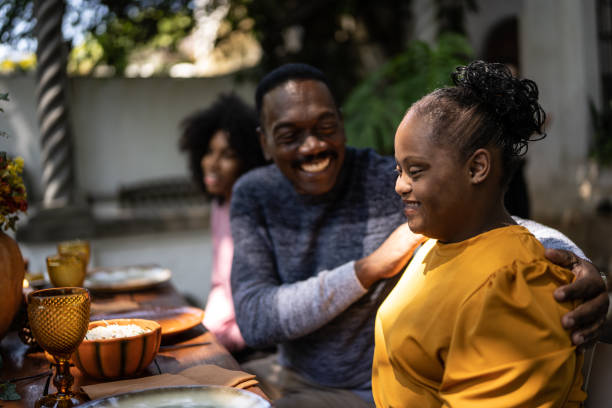 istock Father embracing special needs daughter on the table at home 1345496513