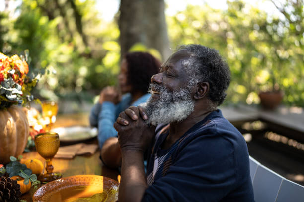istock Senior man saying grace before Thanksgiving lunch at home 1345496520