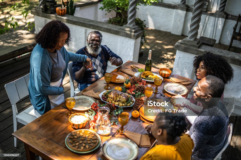Senior woman saying grace before Thanksgiving lunch at home Thanksgiving - Holiday Stock Photo