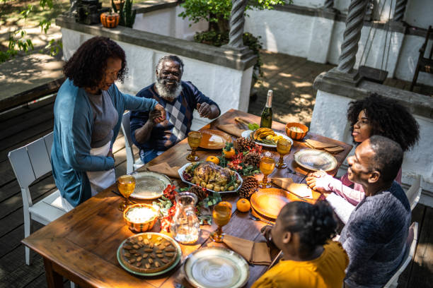 Senior woman saying grace before Thanksgiving lunch at home Senior woman saying grace before Thanksgiving lunch at home family reunion celebration stock pictures, royalty-free photos & images