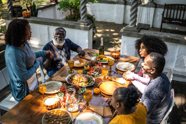 Senior woman saying grace before Thanksgiving lunch at home Senior woman saying grace before Thanksgiving lunch at home saying grace stock pictures, royalty-free photos & images