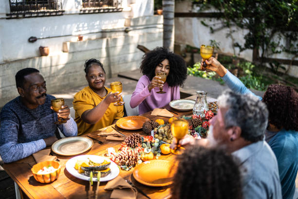 istock Family toasting on Thanksgiving at home - including special needs woman 1345497178