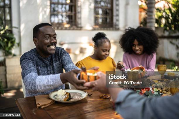 Family Eating On Thanksgiving Lunch At Home Including Special Needs Woman Stock Photo - Download Image Now