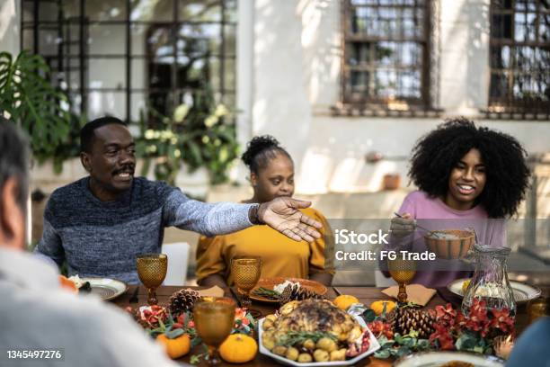 Family Eating On Thanksgiving Lunch At Home Including Special Needs Woman Stock Photo - Download Image Now