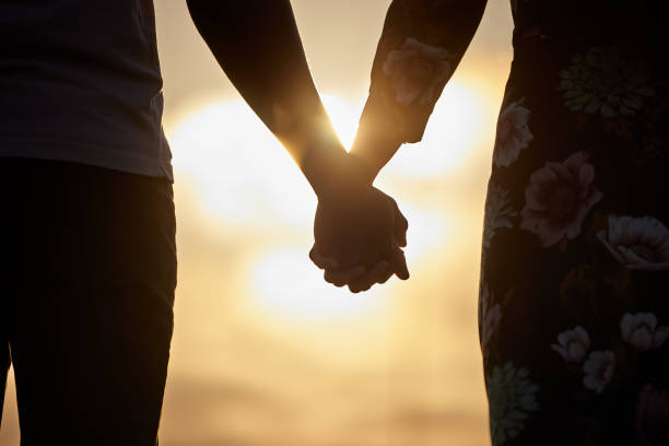 istock Shot of an unrecognizable couple holding hands while watching the sunset 1345497779