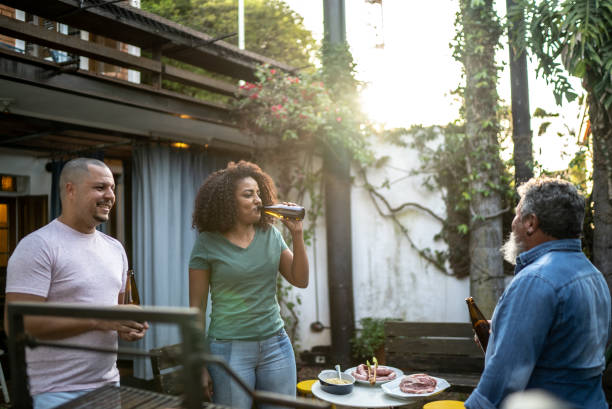 istock Family talking and drinking beer while doing a barbecue at home 1345498549