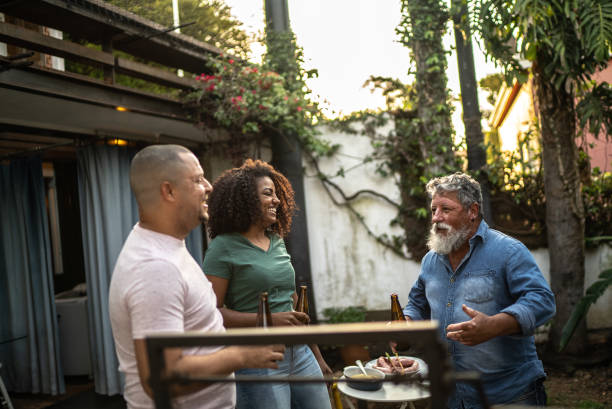 istock Family talking and drinking beer while doing a barbecue at home 1345498565