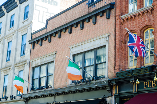 Irish and England flags floating on building walls downtown Old Quebec