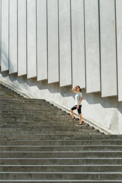 istock Tired Asian woman in tracksuit mops brows on stone steps 1345502572