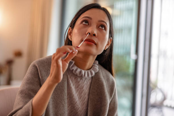 istock Young Woman Using Self Testing Nasal Swab for Coronavirus Detection 1345502825