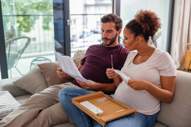 istock Expecting Couple Studying the Instructions for a Self-Test for Coronavirus 1345502830