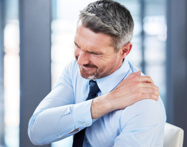 foto de un hombre de negocios maduro que sufre de dolor de espalda en el trabajo - shoulder pain backache men fotografías e imágenes de stock