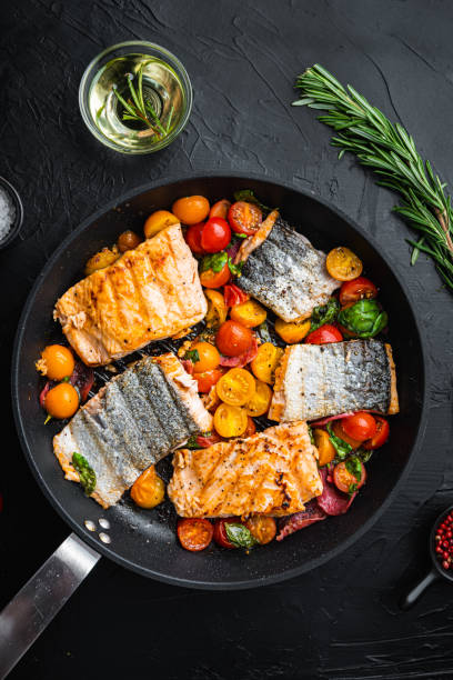 istock Smoky chorizosalmon grilled with cherry tomatoes on black background, top view 1345505409