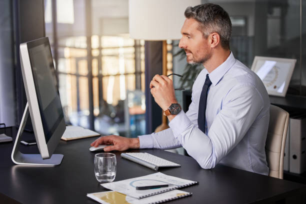 istock Shot of a businessman using his computer while sitting at his desk 1345505795