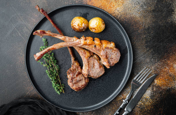 istock Grilled lamb ribs loin, on plate, on old dark rustic background, top view flat lay , with copyspace  and space for text 1345507499