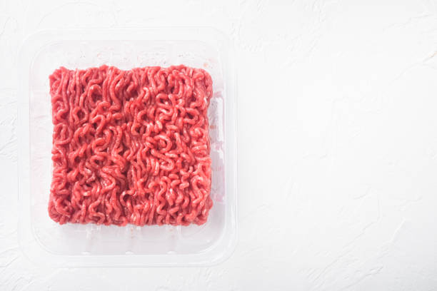 istock Raw minced meat in plastic box, transparent resealable vacuum plastic tray, on white stone  background, top view flat lay, with copy space for text 1345508465