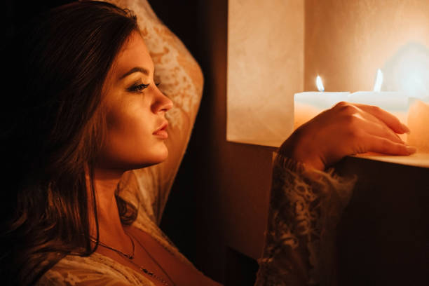 istock Aromatherapy. A sexy brunette in underwear extinguishes candles before bedtime. Romantic setting on Valentine's Day 1345509028