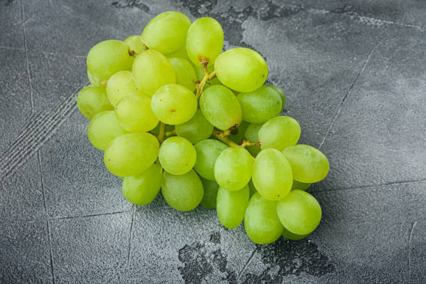 istock Ripe grape, green fruits, on gray stone background 1345509203