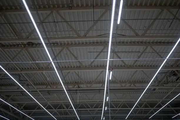 Photo of Lamps with diode lighting under the ceiling of a modern warehouse or shopping center. Engineering of the ceiling lighting of the stadium or exhibition hall.