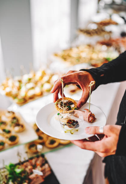 istock male hands take a snack and put it on plate. buffet in a restaurant 1345510778