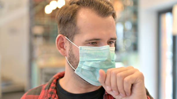 istock Coughing Young Man with Face Mask, Flu 1345512713