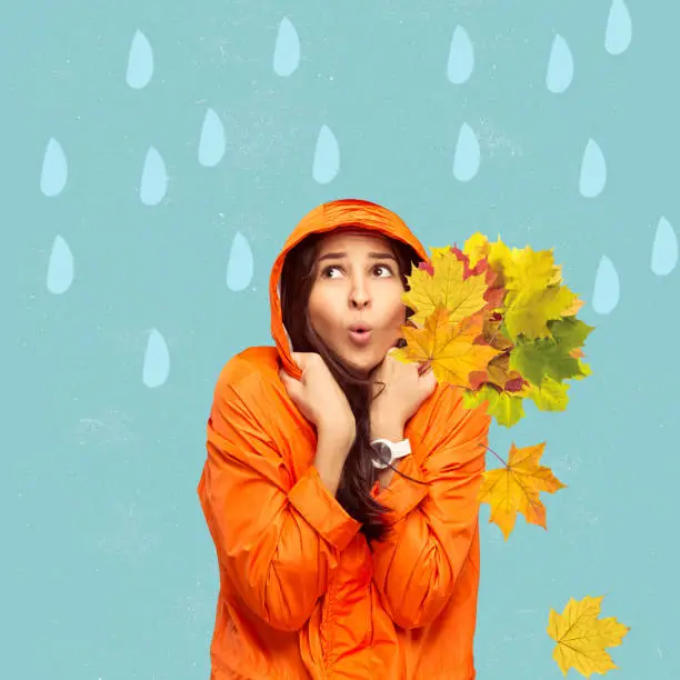 Girl in bright raincoat with autumn leaves under rain. Minimalism, contemporary art collage. Inspiration, idea, urban magazine style. Autumn mood, beauty and nature concept. Artwork. Looks surprised