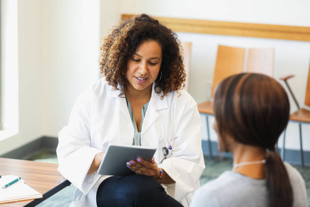 istock Doctor uses digital tablet to review test results with patient 1345513607