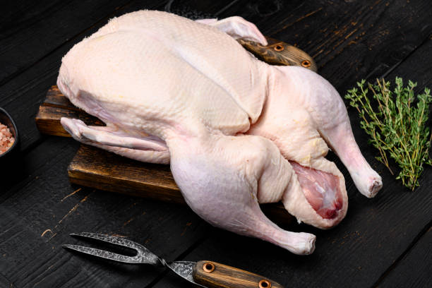 istock Gressingham duck ready to cook with herbs, on black wooden table background 1345514000