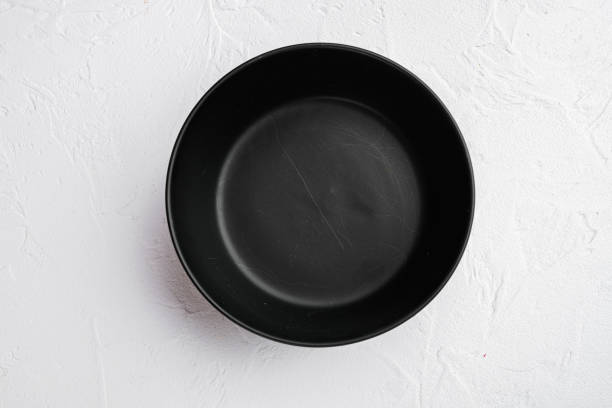 istock Black bowl, with copy space for text or food, with copy space for text or food, top view flat lay , on white stone table background 1345514164