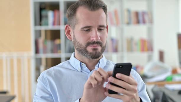 istock Portrait of Young Man using Smartphone 1345515318