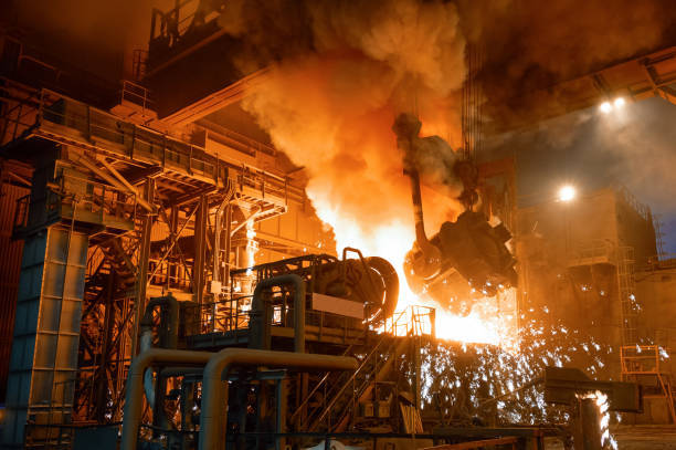 pouring molten metal into a metallurgical electric arc furnace - electric arc imagens e fotografias de stock