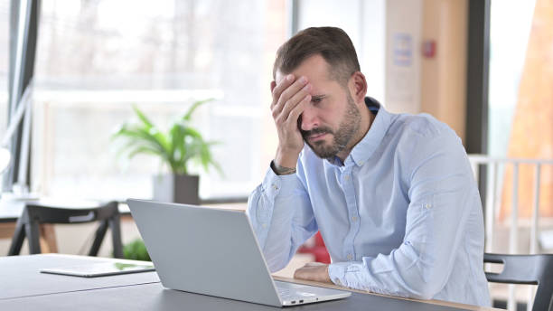 istock Ashamed Young Man Sitting Disappointed at Work, Loss 1345516620