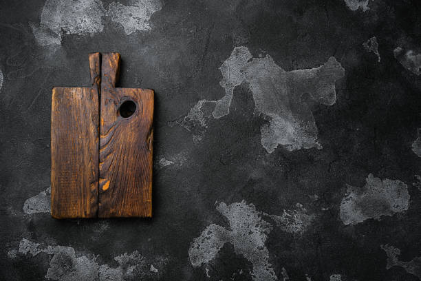 istock Pine wooden cutting board, on black dark stone table background, top view flat lay , with copy space for text or your product 1345516630