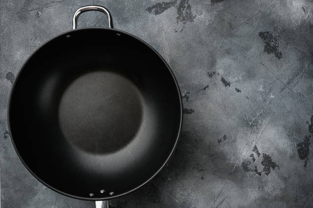 istock Wok pan empty with copy space for text or food with copy space for text or food, top view flat lay , on gray stone table background 1345517532