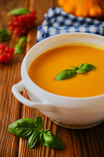 istock Homemade pumpkin soup with cream and basil 1345517730