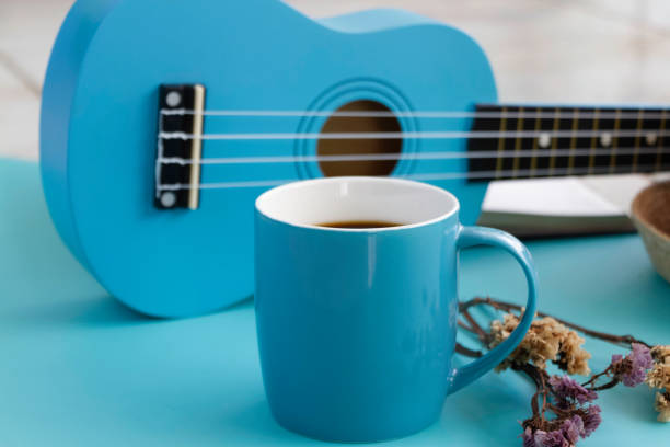 istock Blue ceramic cup with black coffee put beside Ukulele 1345518012