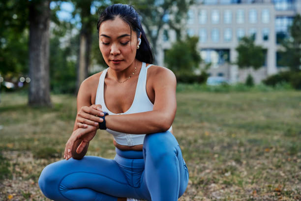 istock Young sportswoman looking and touching on smartwatch screen while exercise outdoors 1345518188