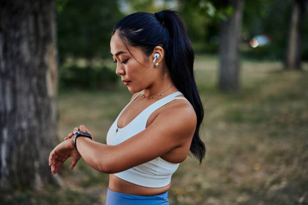 istock Beautiful sportswoman setting up smart watch during workout in park 1345518191