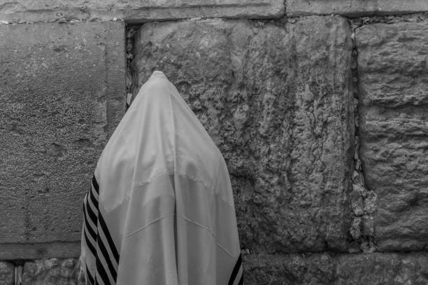 Jewish man praying on the Western Wall in Jerusalem Jerusalem, Israel - June 2019: Orthodox Jew men wailing at Western Wall, an ancient limestone wall in the Old City of Jerusalem, part of the expansion of the Second Jewish Temple wailing wall stock pictures, royalty-free photos & images