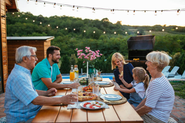 istock Three generations family during dinner, celebrating holiday together in the backyard 1345519293