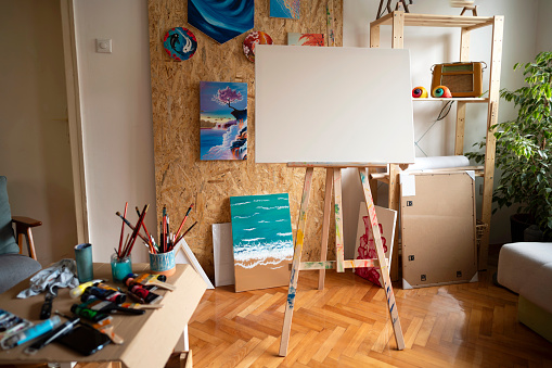 Blank canvas on easels, and painting equipment in the modern home art studio