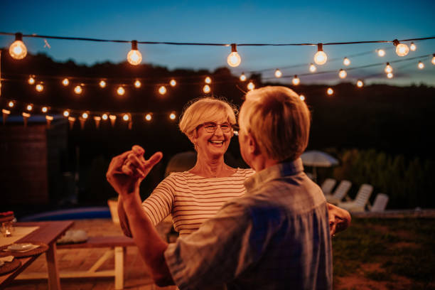 Senior couple dancing outdoors embracing and carefree stock photo