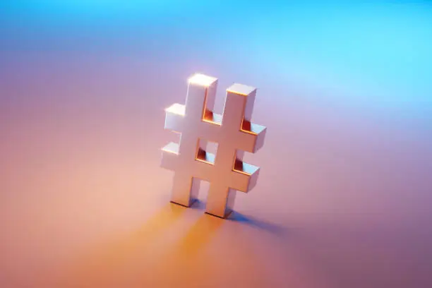 Hashtag symbol sitting over pink and blue background. Selective focus. Horizontal composition with copy space. High angle view.