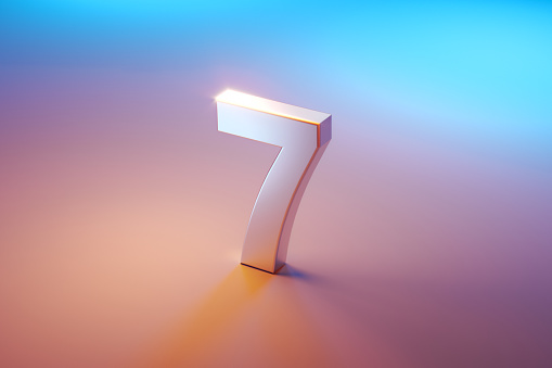 Number seven sitting over pink and blue background. Selective focus. Horizontal composition with copy space. High angle view.