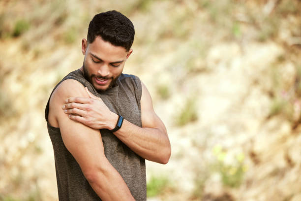 Shot of a sporty young man holding his shoulder in pain while exercising outdoors I might have exerted my muscles too much MUSCLES stock pictures, royalty-free photos & images