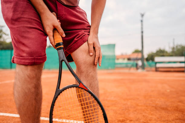 istock Man suffering from knee pain while playing tennis 1345523110