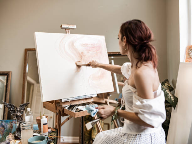 istock Young Caucasian woman painting in studio 1345523189